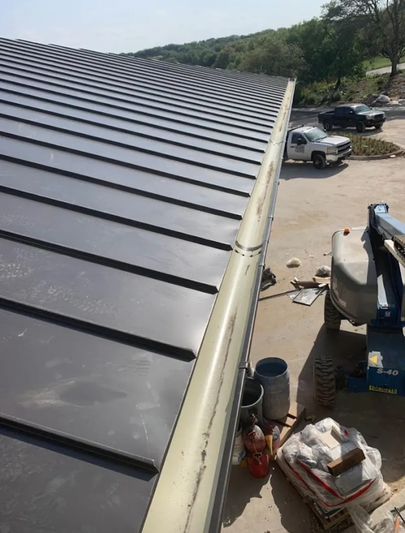 Standing seam panel and gutter detail on a metal roofing jobsite in Wake Forest